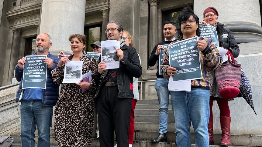 Protesters standing with signs, speaking up against poverty 