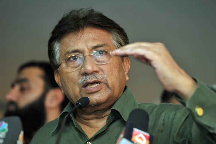 Pervez Musharraf, wearing a green shirt, gestures while speaking at a conference.