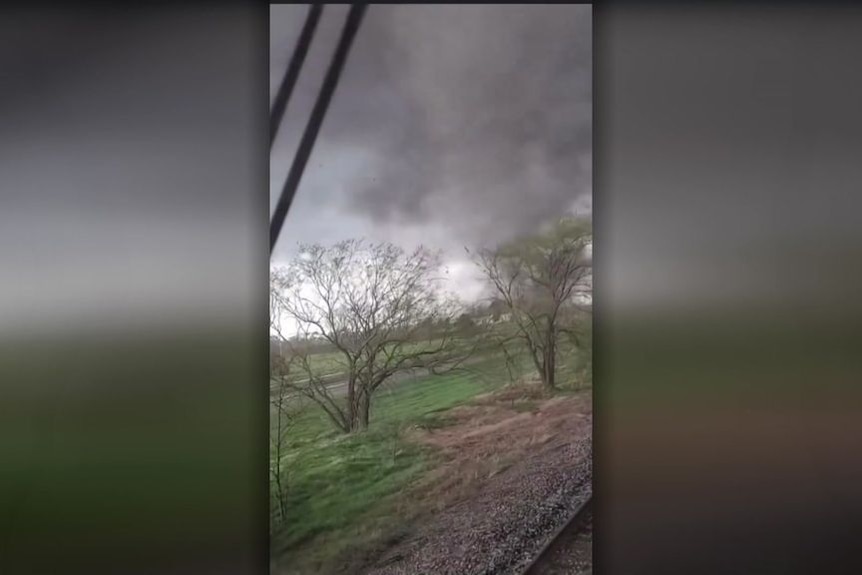 Screengrab of mobile vision filmed from inside a train of a tornado approaching.