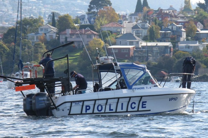 Tasmanian police on boat, searching River Derwent for Bob Chappell's remains.