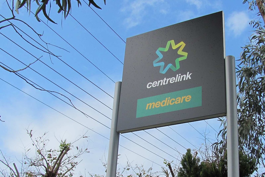 An outdoor sign shows Centrelink and Medicare branding.