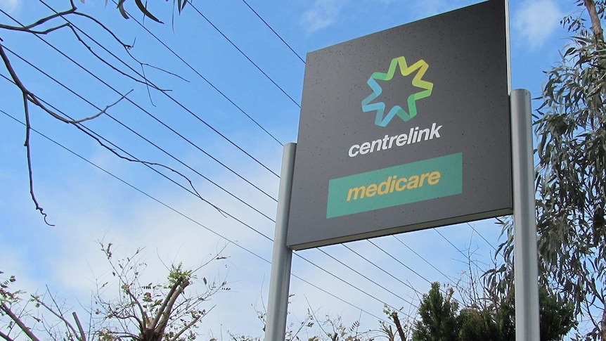 An outdoor sign shows Centrelink and Medicare branding.