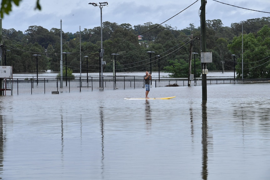 a man on surfboard on floodwtaer