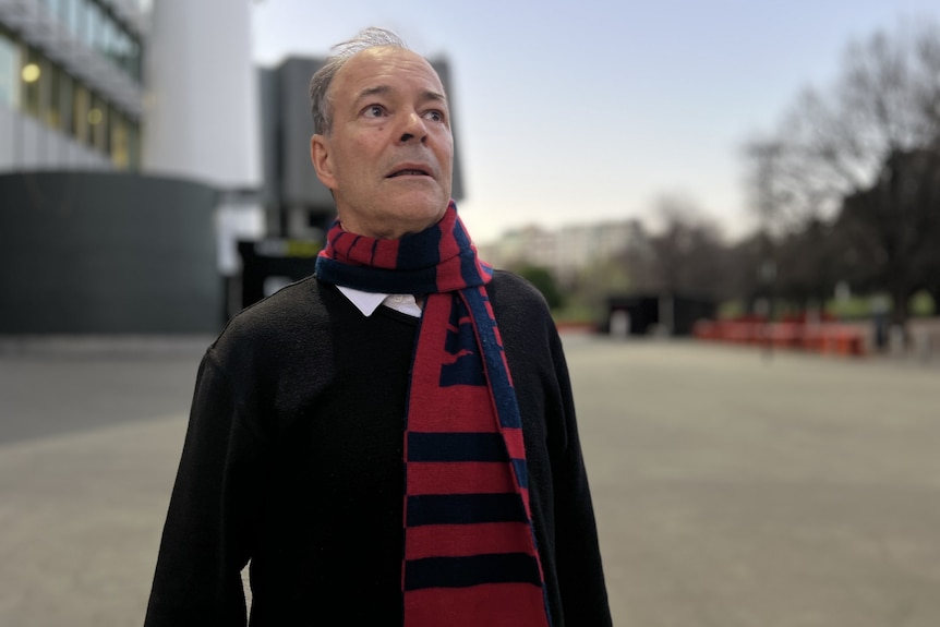 Man looks emotionally into distance outside MCG