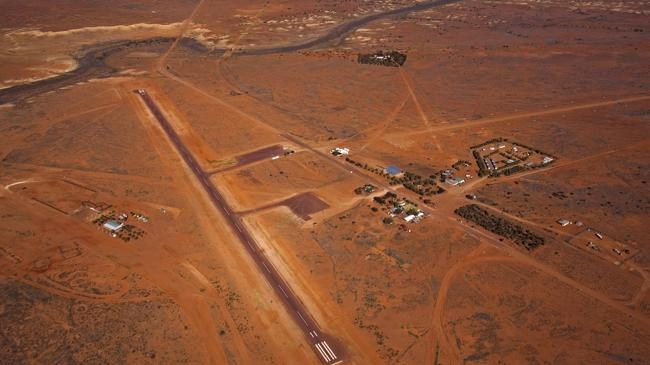 A group of buildings among red dirt from the air