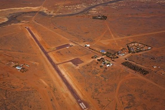 A group of buildings among red dirt from the air