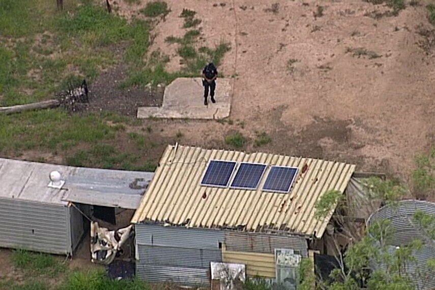 A police officer stands outside a dwelling where a woman was found dead.
