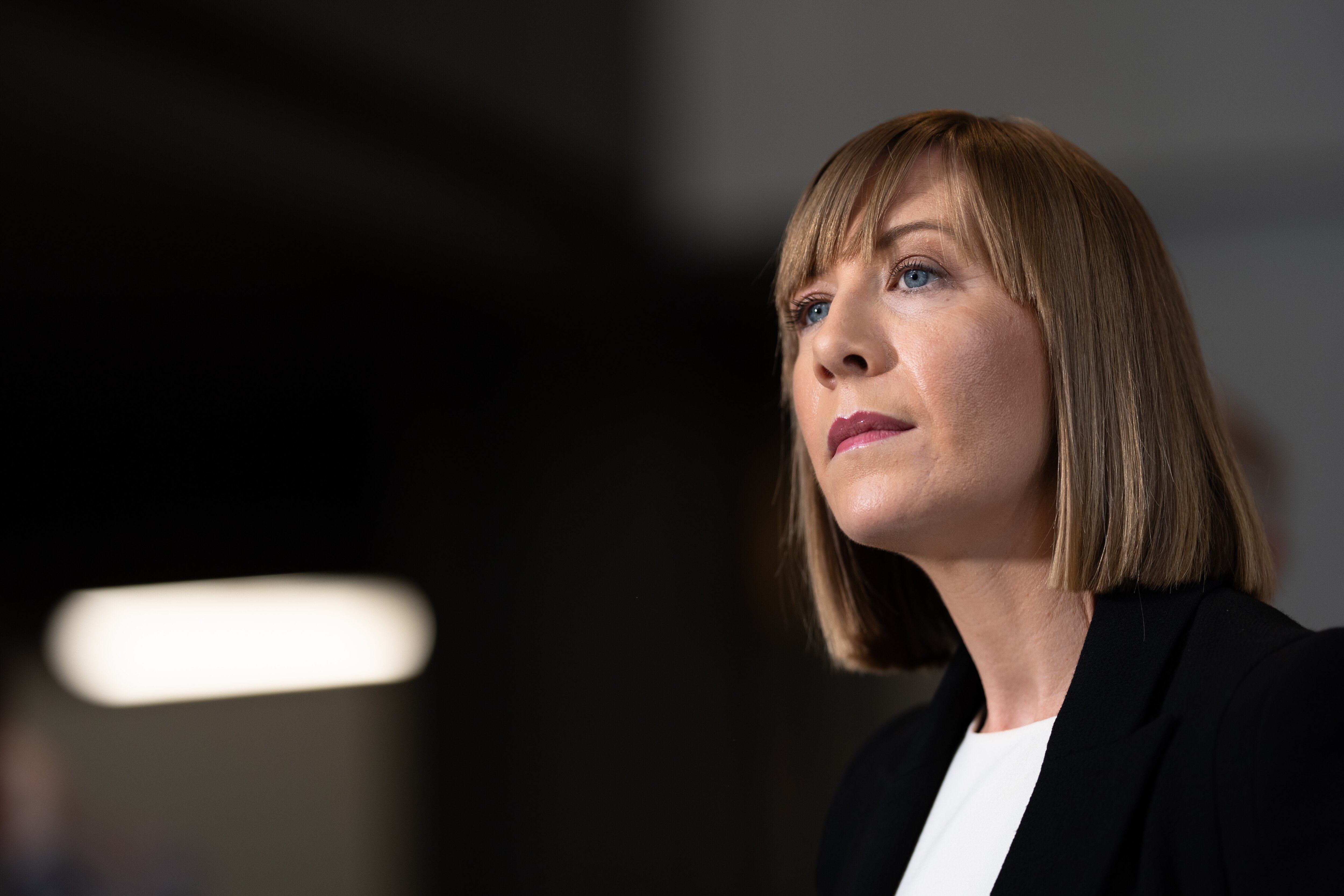 Image of a woman against a blurry background at a press conference