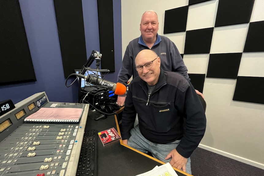Two older bald men in a radio studio