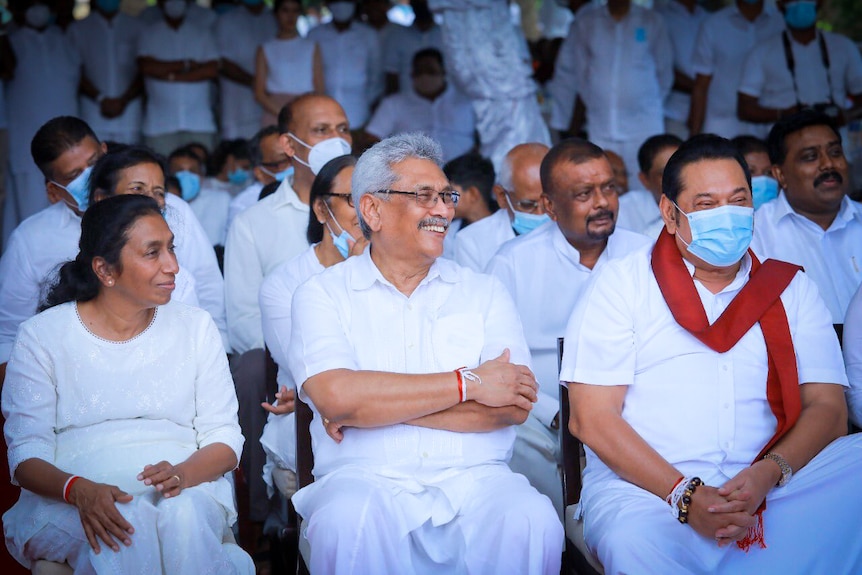 A group of people in all-white outfits and blue surgical masks 
