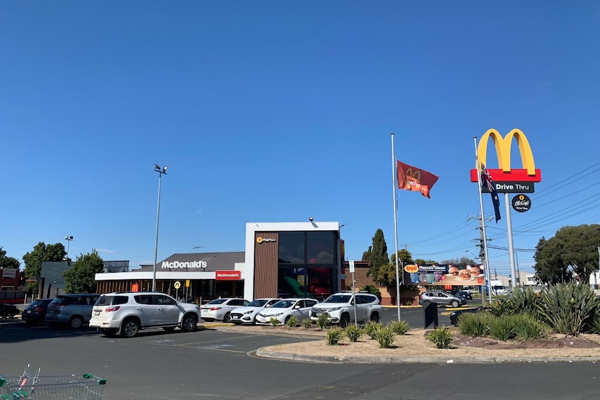 A photo from the car park at a McDonald's restaurant, showing the 'M' sign and cars parked outside.