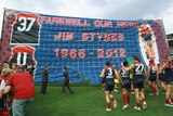 Farewell our hero ... the Demons unfurl a banner in memory of Jim Stynes.