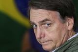 Brazil's new president in front of a flag