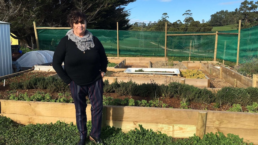 Woman standing in front of hand made herb garden