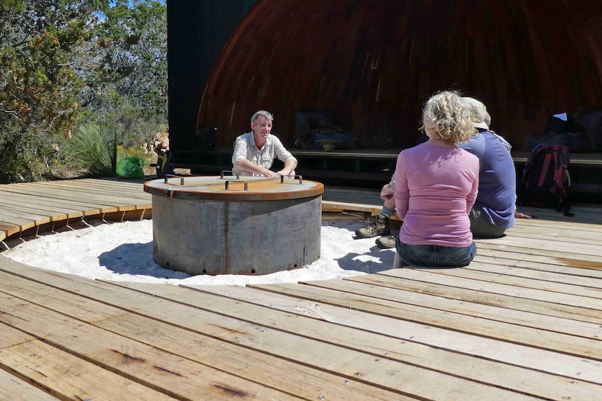Ben Lord talks to tourists in a hut
