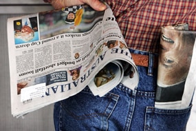 File photo: Man holding The Australian newspaper (Getty Images: Lisa Maree Williams)