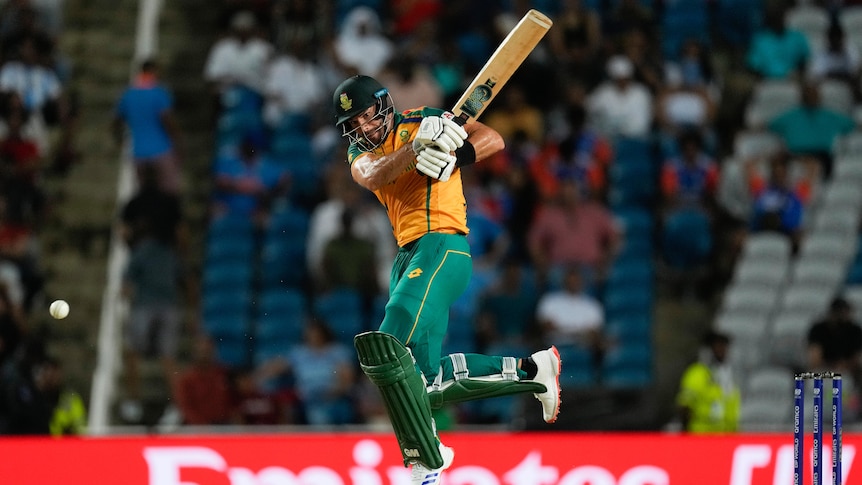 A South African batsman leaps in mid-air as he hits a shot during a T20 World Cup semifinal.