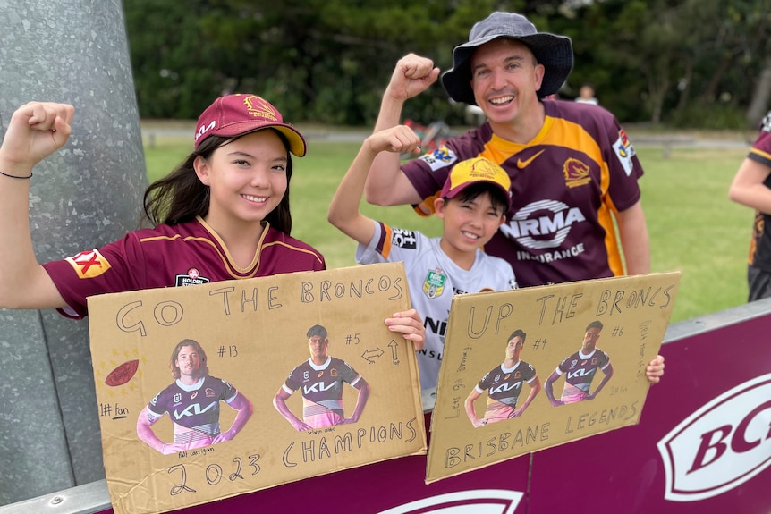 Two children hold handmade Broncos signs