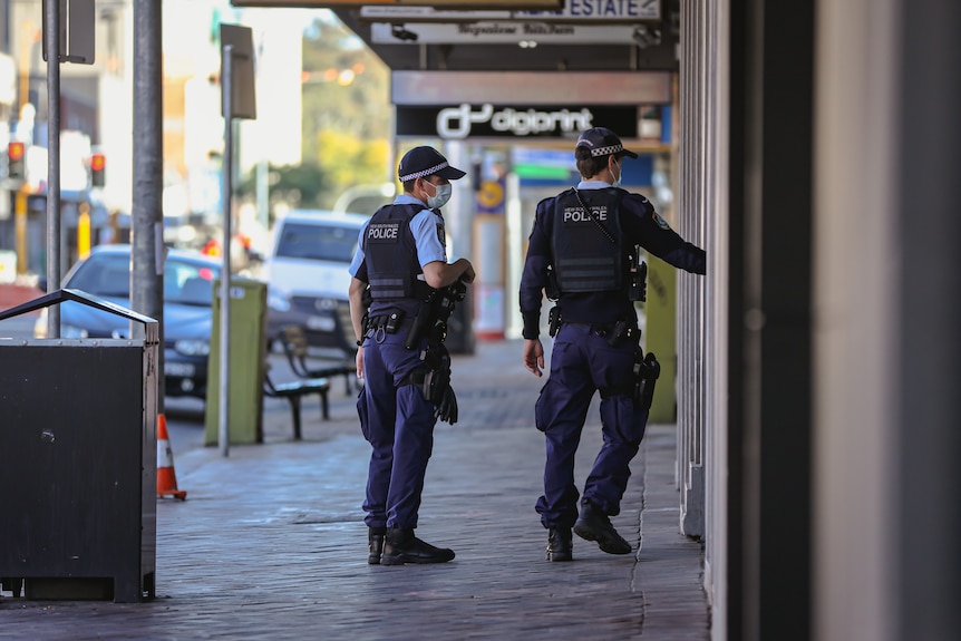 Two police officers walk on the street