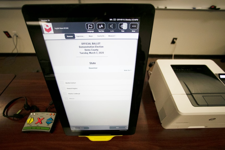 A large screen used for counting ballots sits on a desk