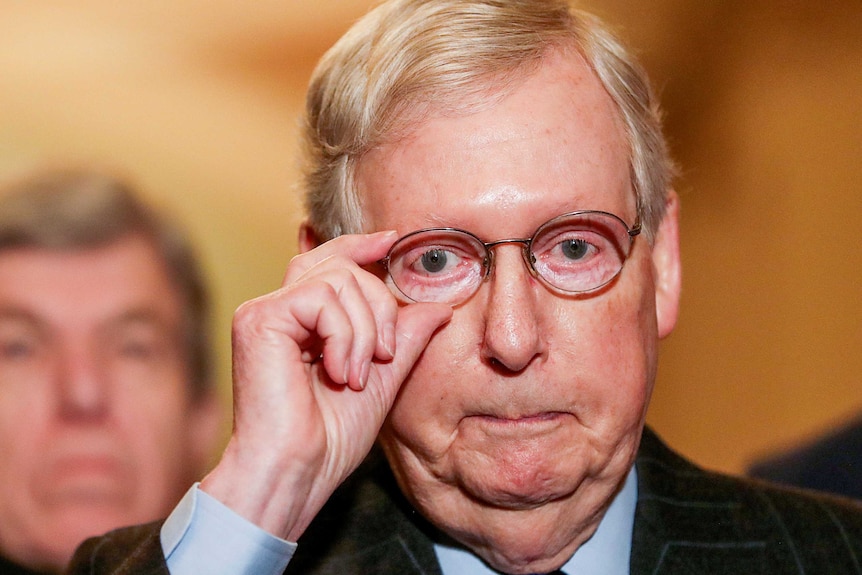 US Senator Mitch McConnell adjusts his glasses