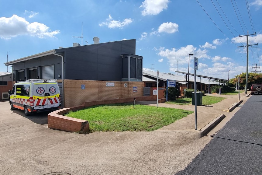 Exterior shot of hospital building with ambulance vehicle 