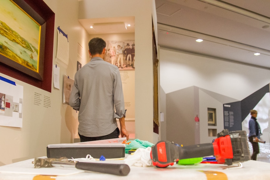 Curator Phillip Manning adds touches to the 100% Brisbane exhibition ahead of its opening on Friday.