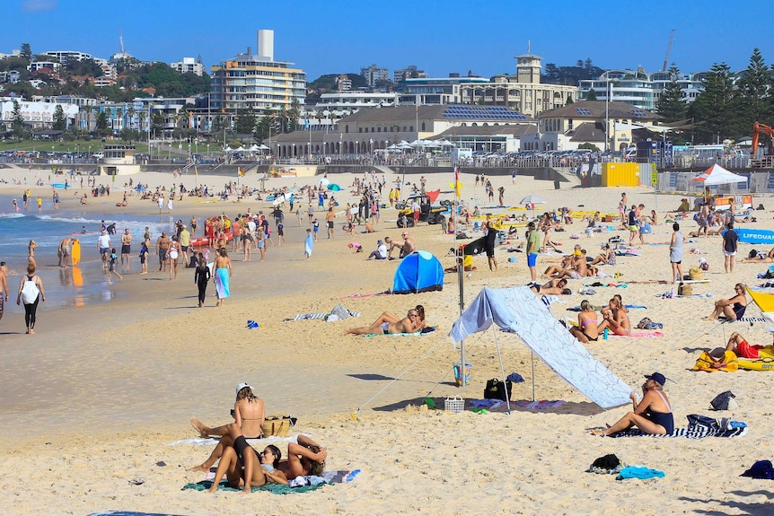 Down the length of Bondi Beach, crowds of people can be seen.