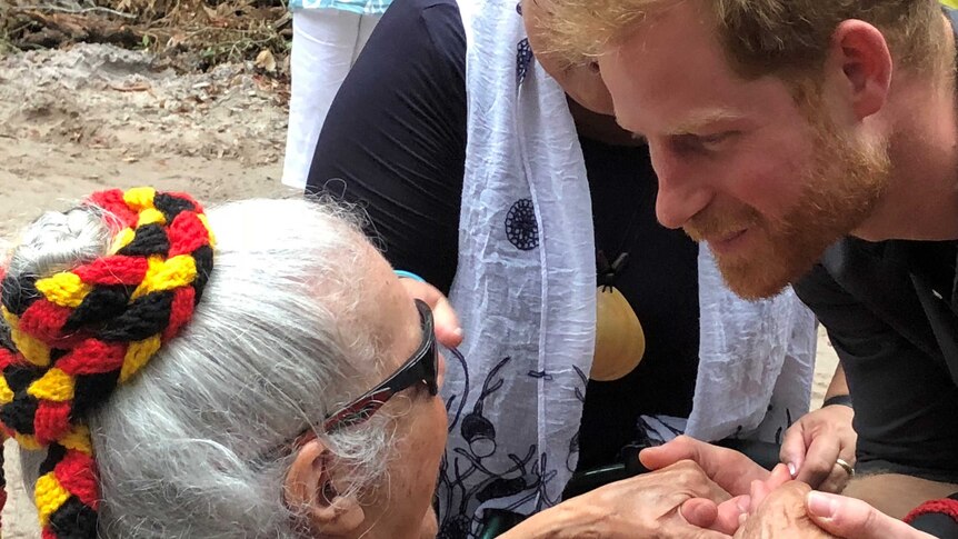 Close up of Prince Harry holding hands with and speaking to with Indigenous elder Auntie Joyce.