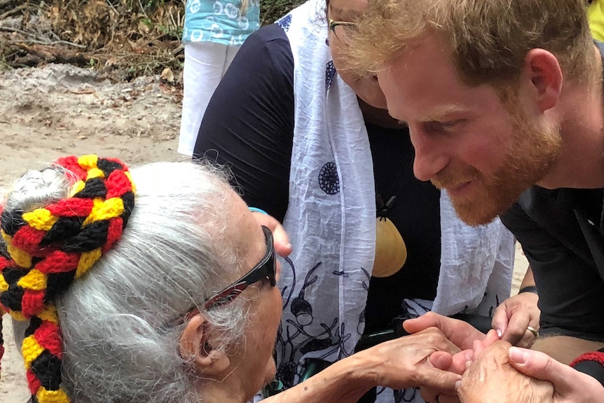 Close up of Prince Harry holding hands with and speaking to with Indigenous elder Auntie Joyce.