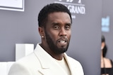 Sean "Diddy" Combs wearing a white suit jacket.