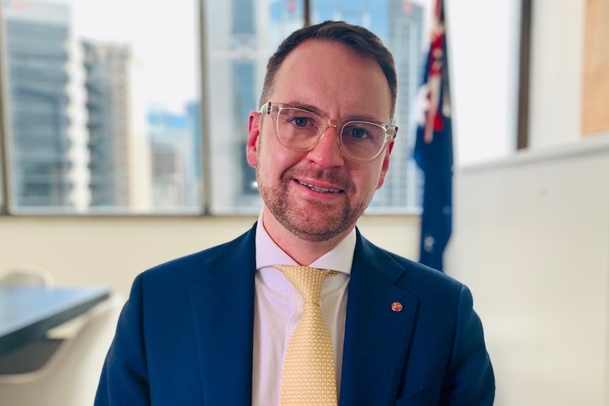 Liberal backbencher and senator Andrew Bragg stands in an office.