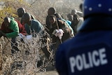 A policeman fires at protesting miners outside Lonmin's Marikana platinum mine.