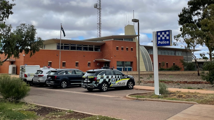 A red brick building with police cars parked in front of it
