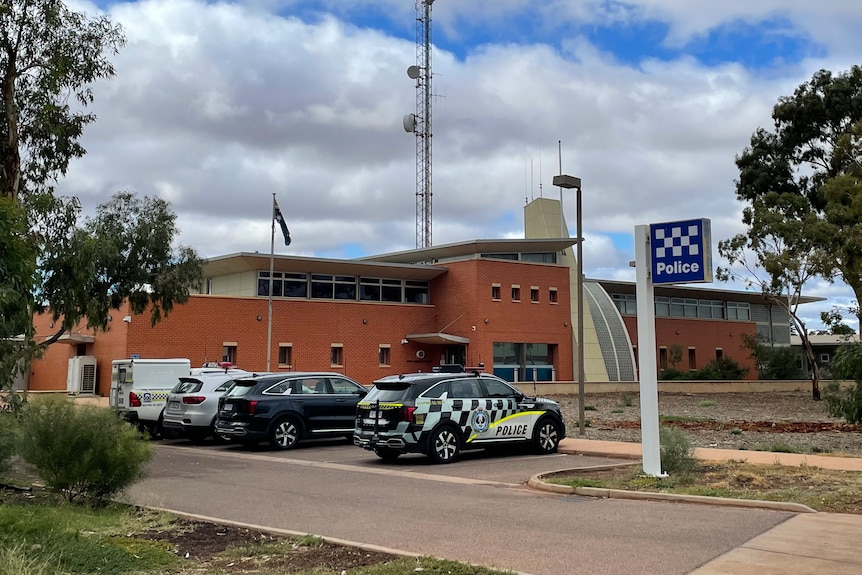 A country police station beneath a cloudy sky.