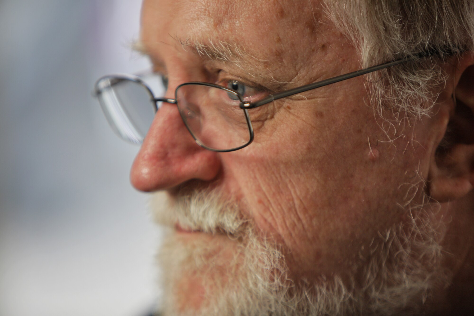 A close-up of a man's face. He is wearing glasses.