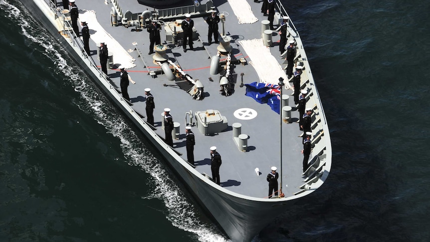 Crew onboard a Royal Australian Navy ship as it makes its way along Sydney Harbour