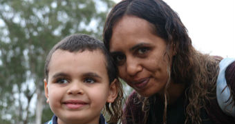 Deborah Lonsdale smiles and leans down to pose with young son Cameron