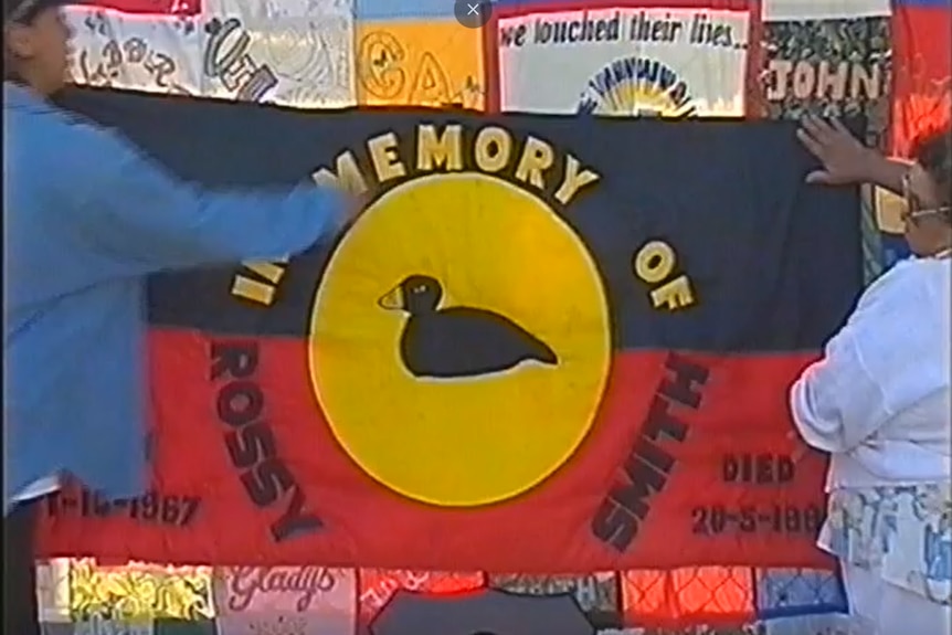 An indigenous flag with the writing In memory of rossy smith on it. 