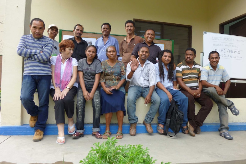 Jill Jolliffe standing with a row of East Timorese people from the Living Memory project.