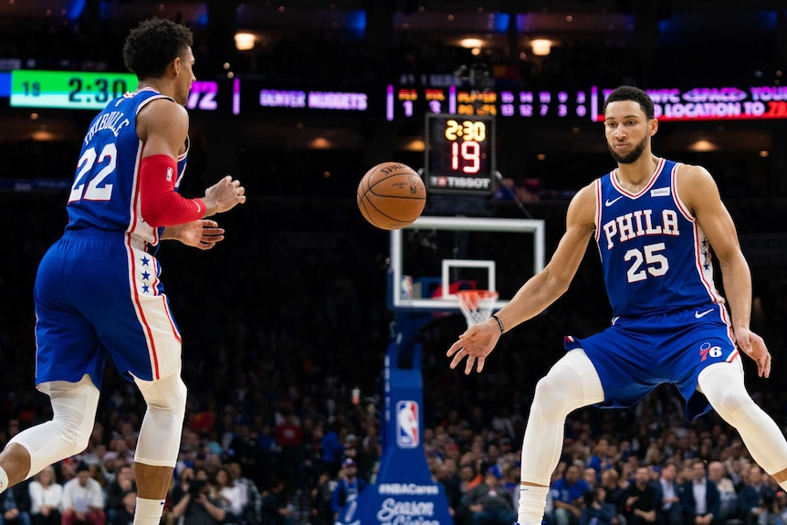 Ben Simmons (right) hands the basketball off to Matisse Thybulle while playing for the Philadelphia 76ers.
