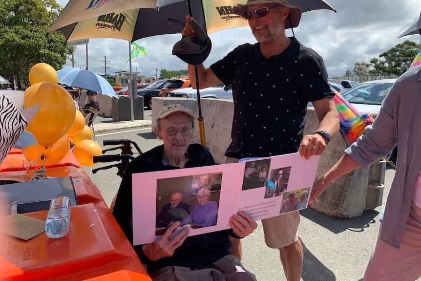 man in wheelchair with photo album