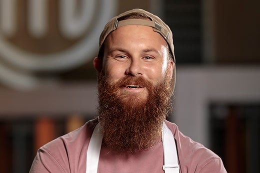 Chef folds his arms and smiles for the camera. 