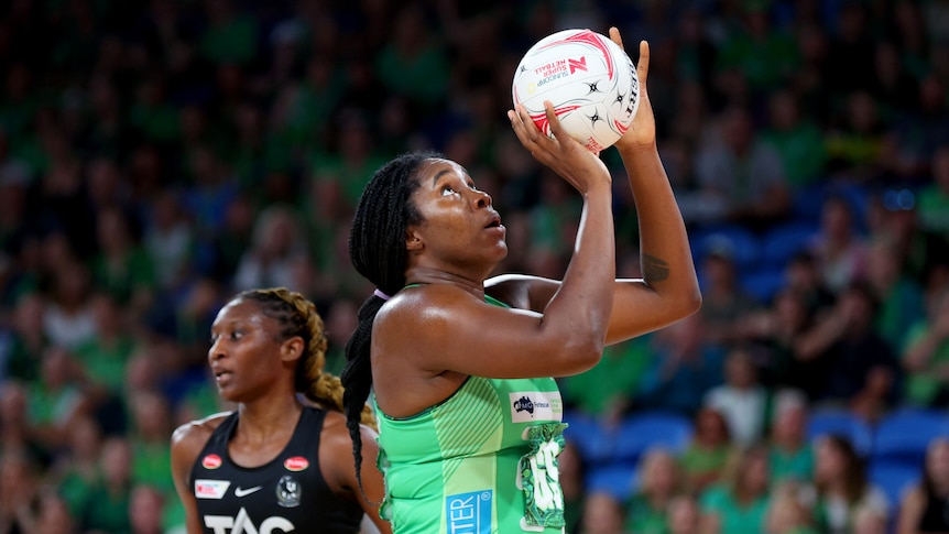 Jhaniele Fowler looks up and holds a netball in both hands