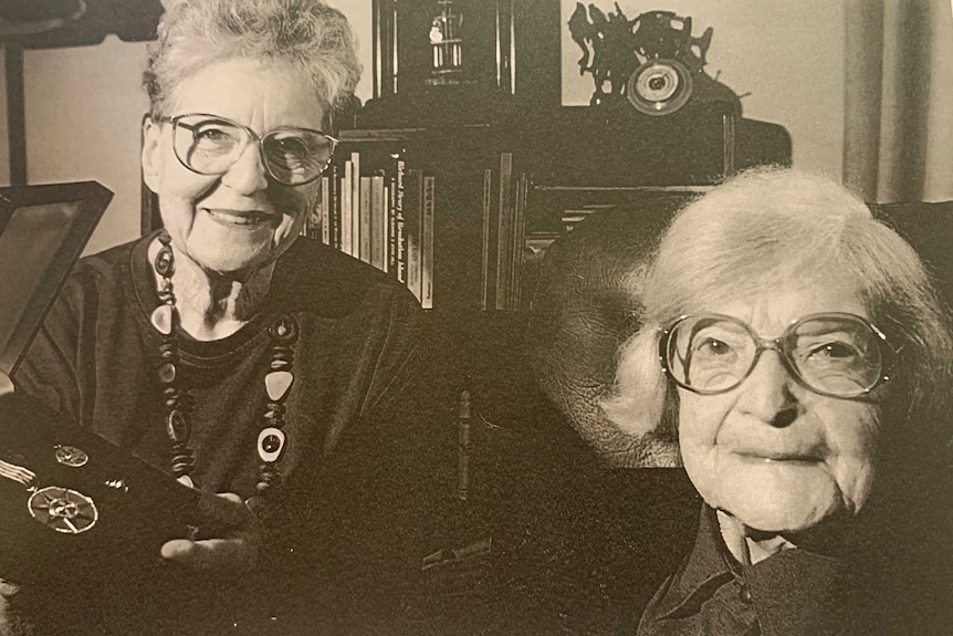 Two women together with one holding medals.