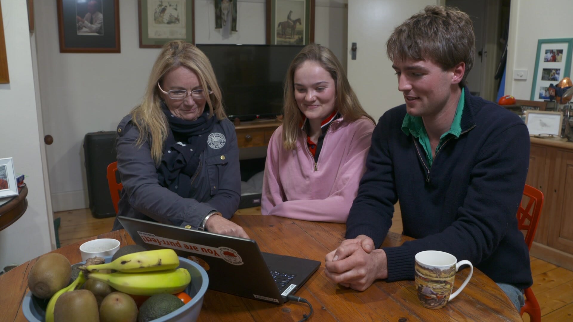 Photo of three people watching a computer screen.