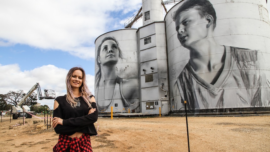 Russian artist Julia Volchkova standing in front of her silo art work at Rupanyup in western Victoria.