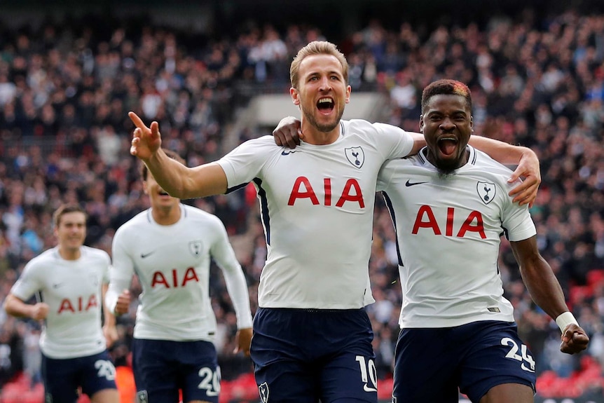 Harry Kane and Serge Aurier with their arm around each other gesture to the crowd at Wembley as they celebrate a goal.