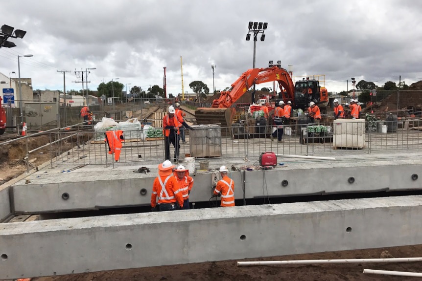 Concrete bridge section and workers.