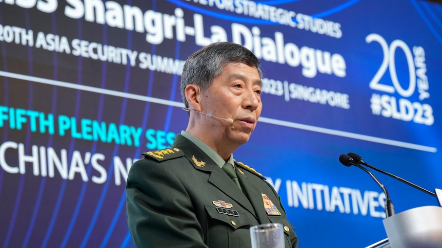 Li Shangfu  in uniform speaks at the lectern of a forum in Singapore